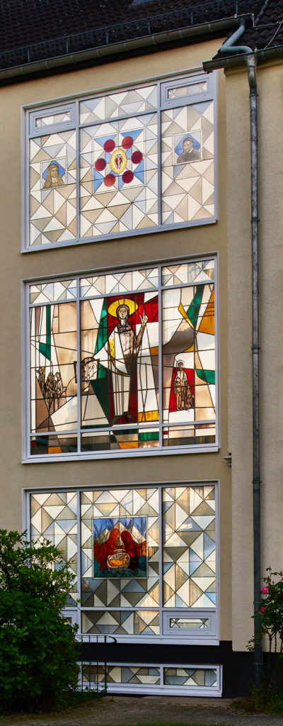 Fenster im Provinzhaus der Vinzentinerinnen in Köln-Nippes, Einrahmung mit Motiven von Clemens Hillebrand. Mitteleres Fenster von Will Thonnet.